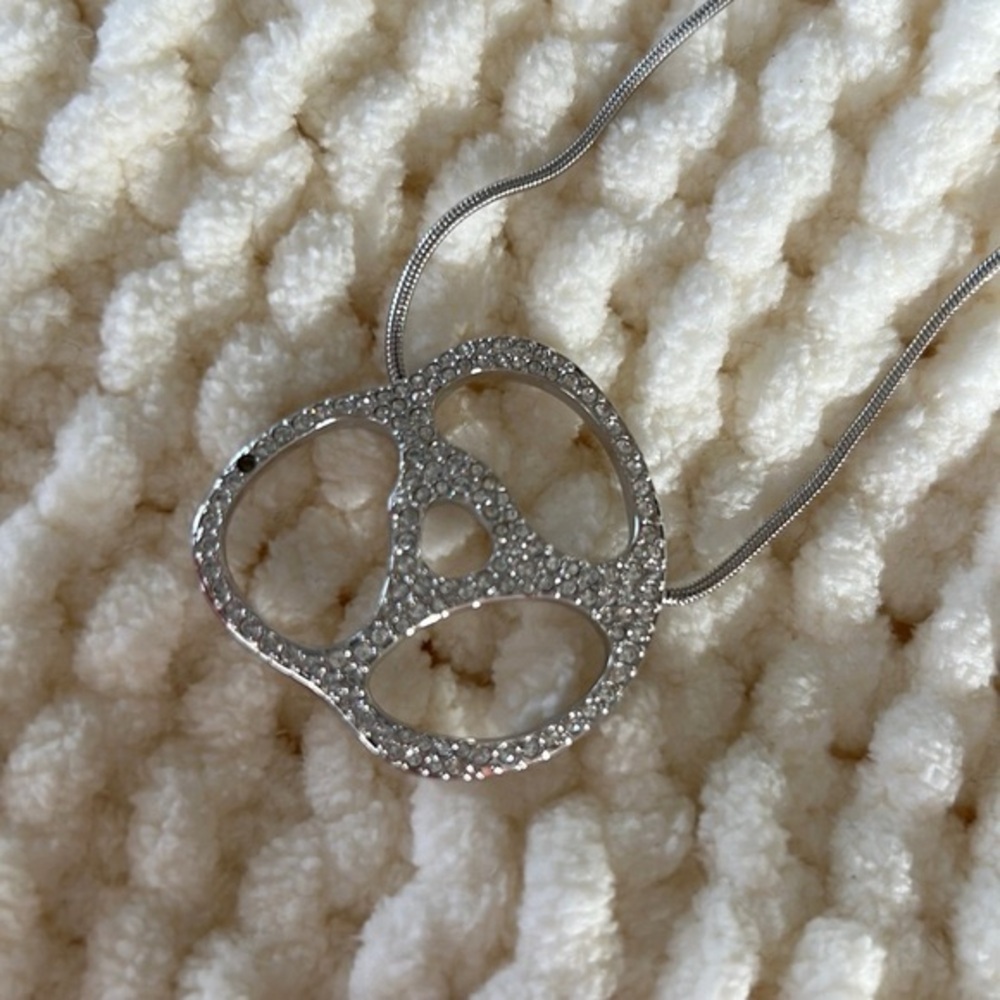 Pretzel shaped pendant with crystals.